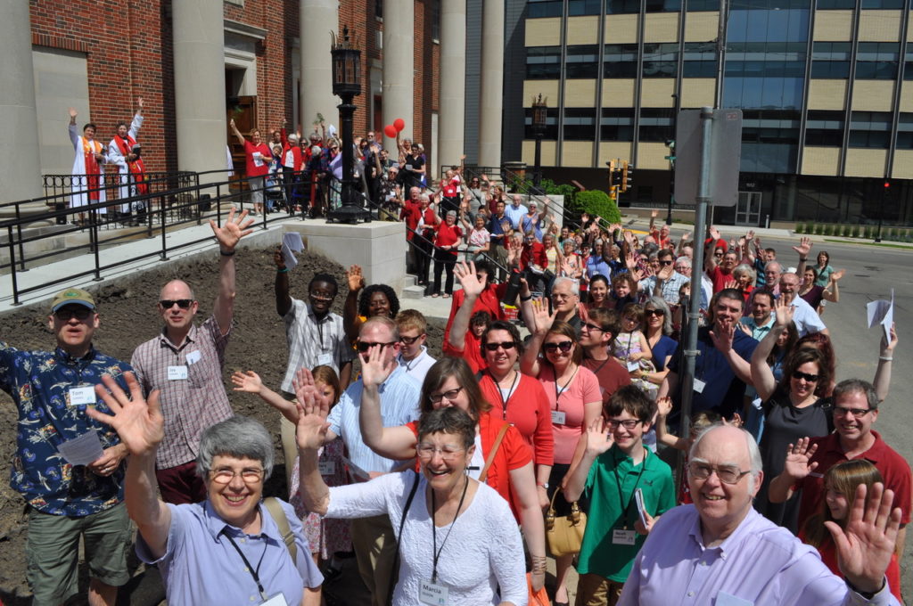 Members of First Congregational UCC Madison on the front steps of the church waving at you